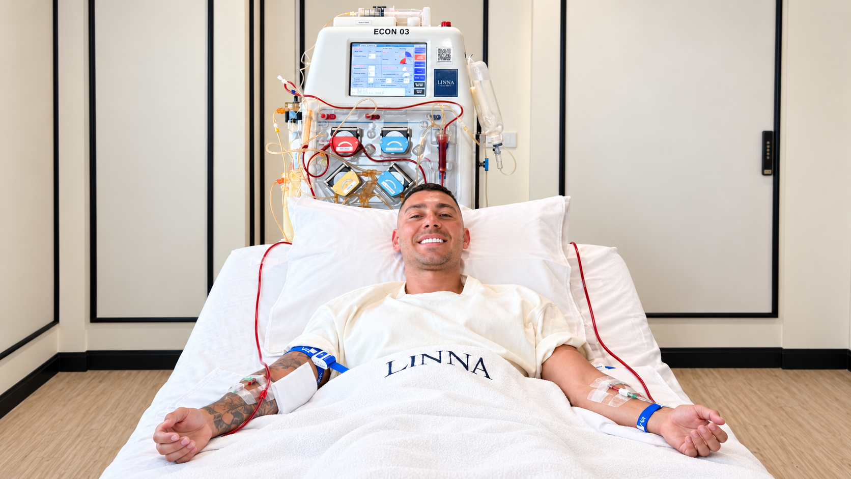 Smiling patient resting in a treatment bed with the DFPP apheresis machine behind him at LINNA Clinic Bangkok